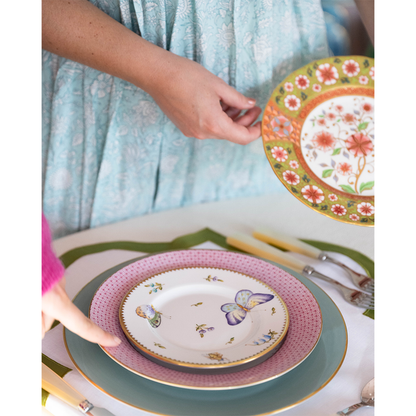 Round bread and butter plate with butterfly and floral meadow design on white background.