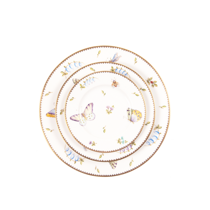 White ceramic bread and butter plate with delicate butterfly and floral designs, gold trim edge.
