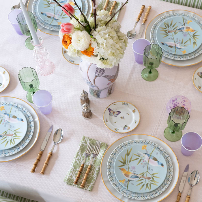 Round bread and butter plate with pastel butterfly and floral meadow design on white background.