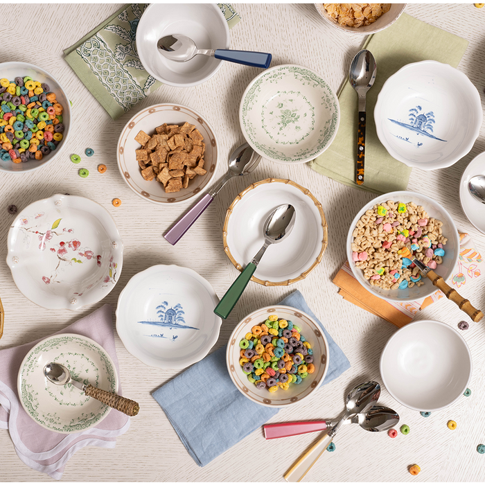 Round natural bamboo cereal bowl with smooth finish shown with colorful cereal inside and empty bowls nearby.