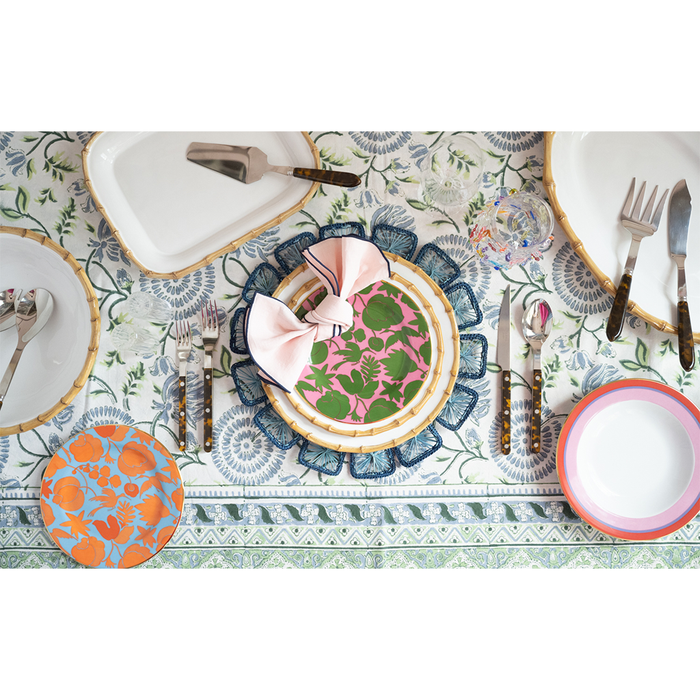 Rectangular natural bamboo serving platter with smooth finish on patterned tablecloth.