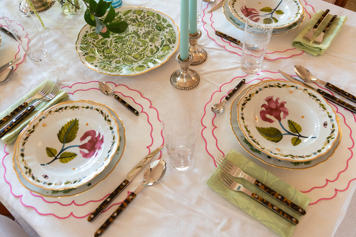Pink Italiano Bloom deep plate with floral design on white scalloped edge dinnerware set on tablecloth.