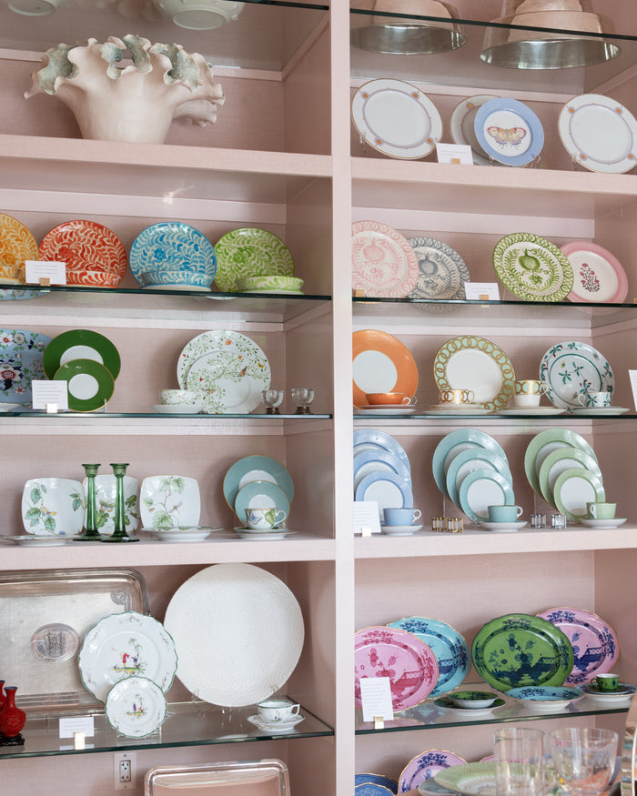 Cornflower blue lace-patterned bread and butter plate displayed on shelf with matching dinnerware sets.