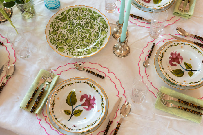 Large ceramic platter with green floral pattern on white background, displayed on festive table setting.