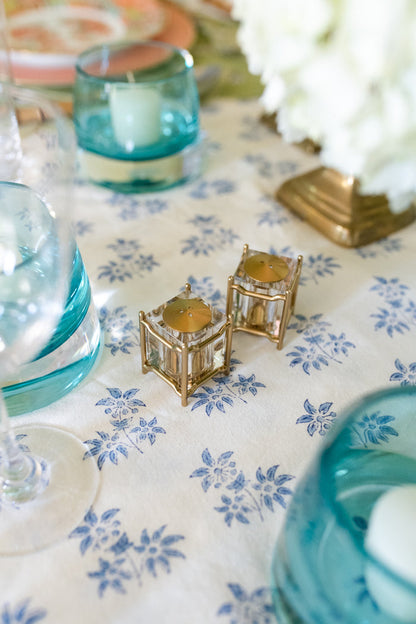Gold New York Diner salt and pepper shakers with geometric cage design on floral tablecloth.
