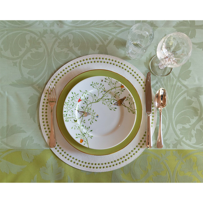 Chartreuse Olivia Dot placemat with white and green patterned plate, gold flatware, and glassware on floral tablecloth.