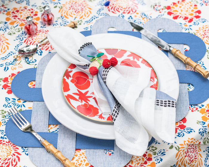 Whitewash ceramic dinner plate with slightly raised rim, styled with floral salad plate and white linen napkin on colorful.