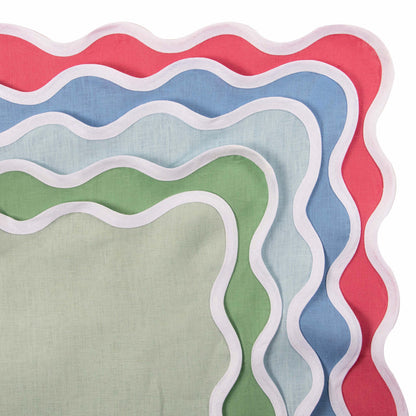 Stack of scalloped linen napkins in sky blue, green, and coral with white trim.