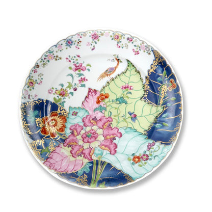 White dinner plate with colorful floral and tobacco leaf design in pink, green, blue, and orange hues.